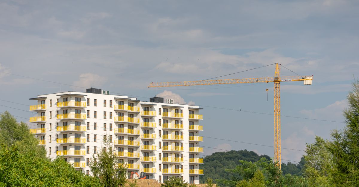 View of modern apartment building and construction crane in Trzebinia, Poland.